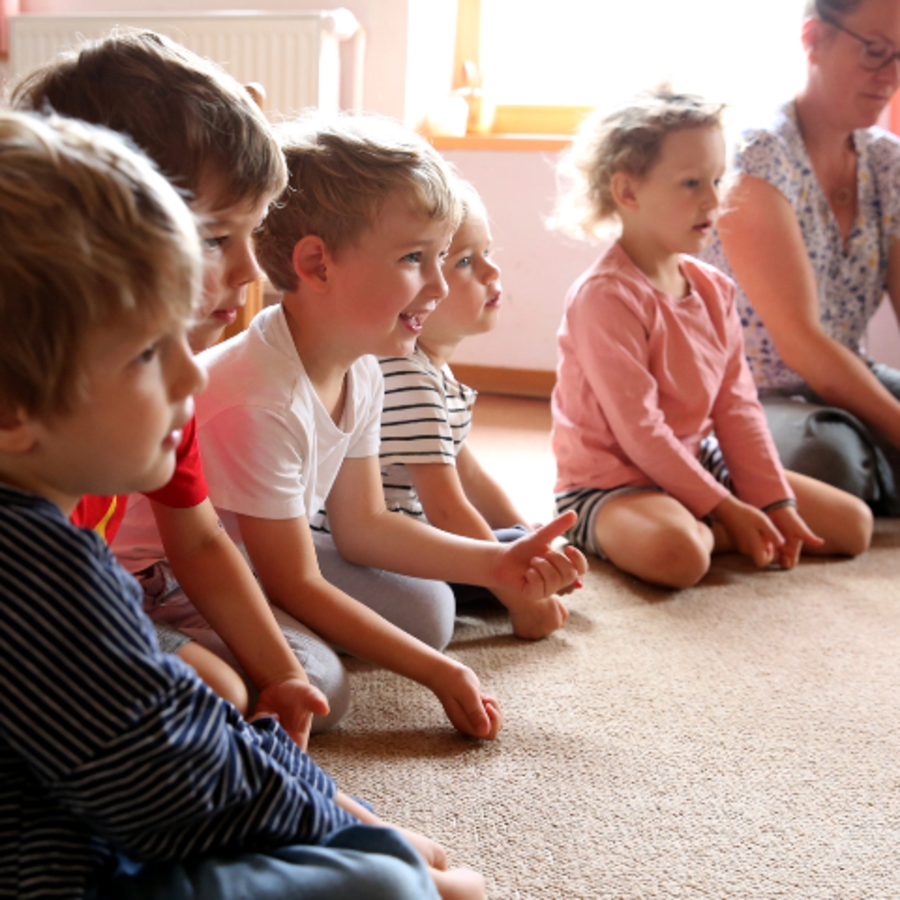 Foto von kleinen Kindern, die im Kreis sitzen