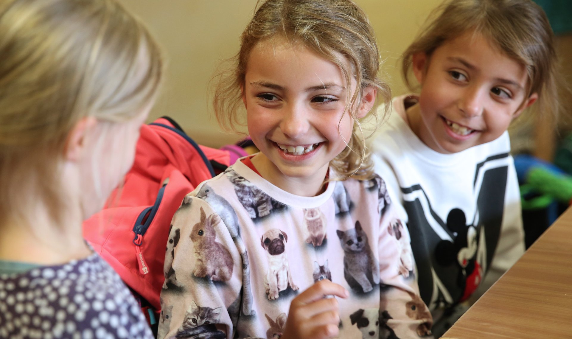 Fröhliche Kinder lächeln sich an
