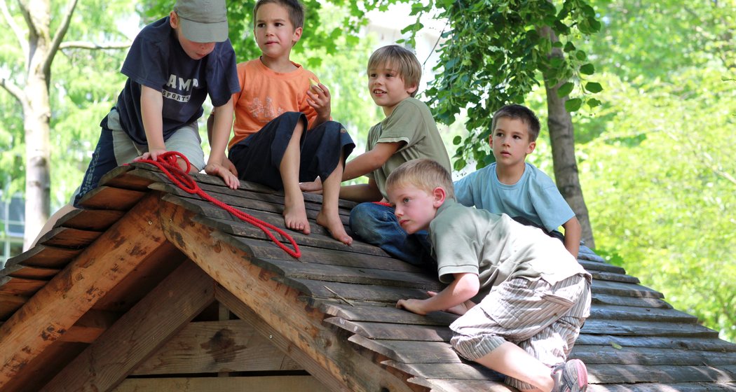 Foto von Kindern, die auf einem Holzdach spielen