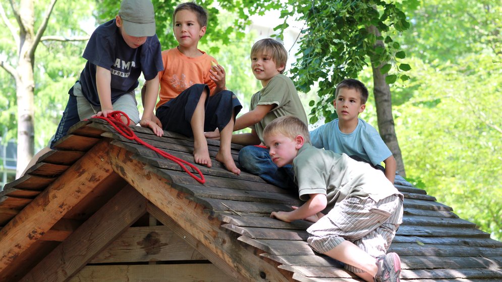 Foto von Kindern, die auf einem Holzdach spielen
