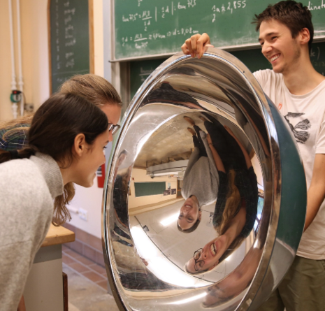 Kinder spiegeln sich in einer großen Metallschale